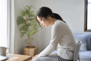 窓着までうつむきながら一人で考え込む女性のイメージ